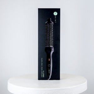 Hairbrush packaging on a white pedestal with a light gray background