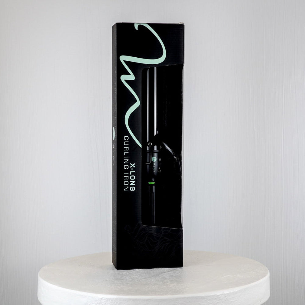 Black packaging of a curling iron on a white platform with a light gray background