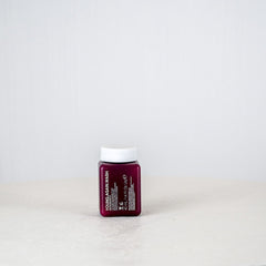 Small red bottle with a white cap on a light gray background